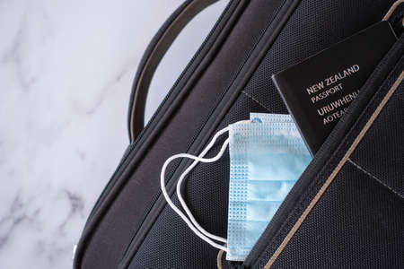 New Zealand Travel During Pandemic - New Zealand Passport and Mask in Carry On Bagの写真素材