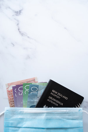 New Zealand Travel During Pandemic - New Zealand Passport, Money Wearing Mask on Table with Copy Space Verticalの写真素材