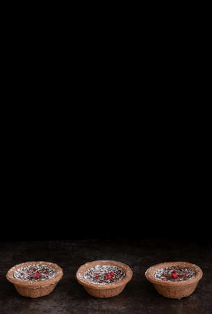 Line of Delicious Chocolate Tarts on Dark Background with Copy Space Verticalの写真素材