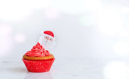Individual Cupcake Christmas Cupcake with Santa Topper on White Background with Copy Spaceの写真素材