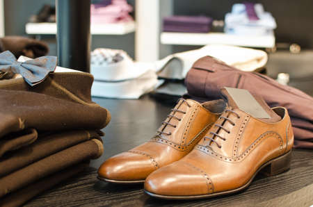 Shoes, shirts and other clothes in a men fashion store.