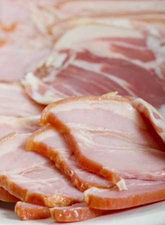 Slices of smoked bacon on a plate, closeup.の写真素材
