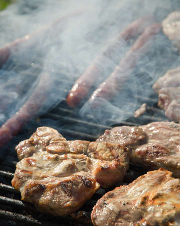 Pork meat and sausages on a grill.の写真素材