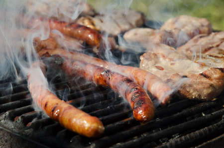 Pork meat and sausages on a grill.の写真素材