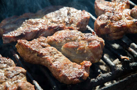Pork meat and sausages on a grill.の写真素材