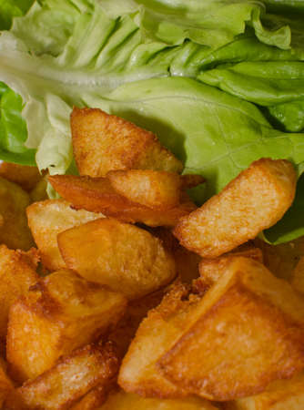 Fried potatoes and green saladの写真素材