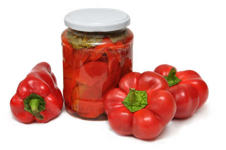 Sweet red peppers in a glass jar on a white の写真素材