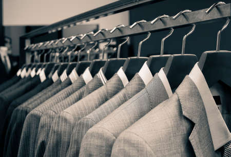 Men suits hanging in a clothing store.の写真素材