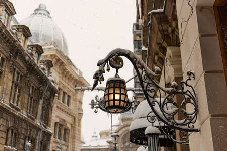 Fancy lantern covered with snow in a winter day - urban concept.の写真素材