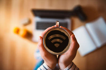 Girl holding a cup of coffee with wi-fi symbol.