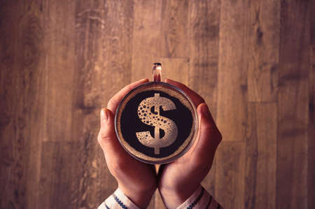 Girl holding a coffee cup with a dollar sign inside.の写真素材