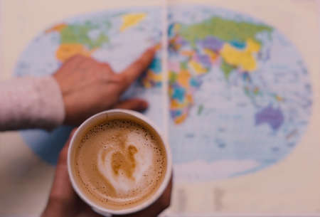 Planning a trip around the world with a coffeeの写真素材