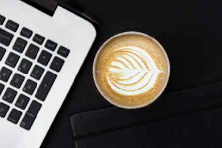 Coffee, notebook and laptop on black, business concept.の写真素材