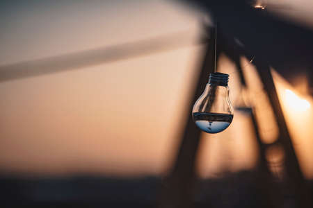 Light bulb filled with water at sunset - warm tonesの写真素材