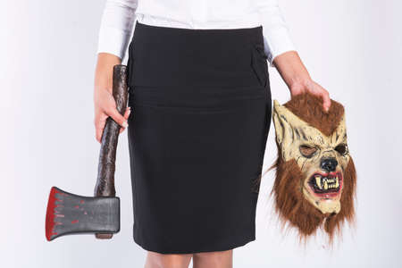 Girl with a wolf mask and a bloody axe in business clothingの写真素材