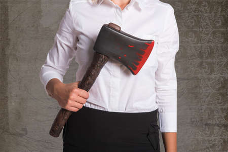Girl in a business clothing with a bloody axeの写真素材
