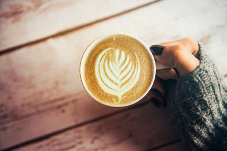 Girl holding a cup of coffee in winterの写真素材