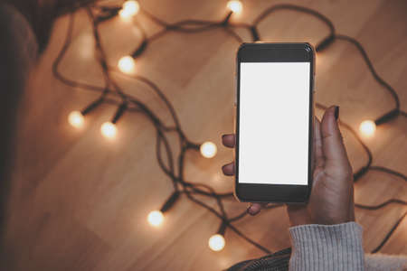 Girl using mobile phone in a home atmosphere - hipster look with blank space.の写真素材