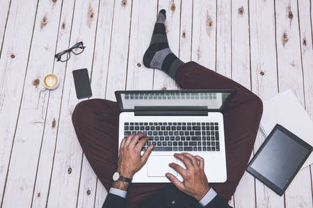 Men in elegant clothign working at home, on the floorの写真素材