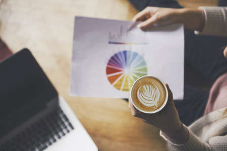 Cozy business atmosphere - girl with a graphic and a coffee.の写真素材