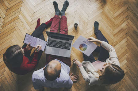 Working at home concept - Two girls and a guy with a laptop, startup concept.の写真素材