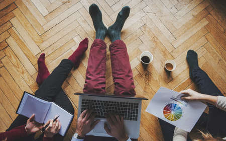 Working at home concept - Two girls and a guy with a laptop, startup concept.の写真素材