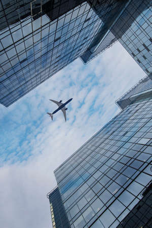 Airplane flying over business area.の写真素材