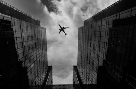 Airplane flying over business area.