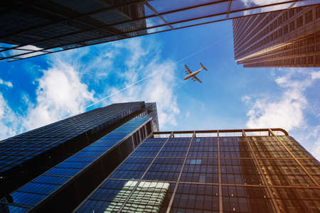 Airplane flying over business skyscrapers.の写真素材