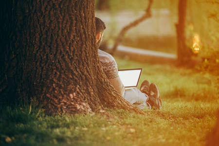 Working in nature - man with a laptop in a parkの写真素材