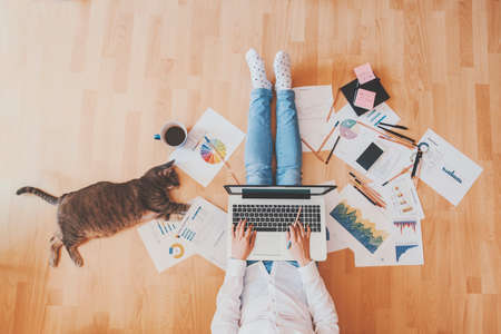 Working home concept - girl with smart phone, laptop and business reports.の写真素材