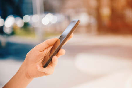 Girl with a smart phone in the city in a sunny day