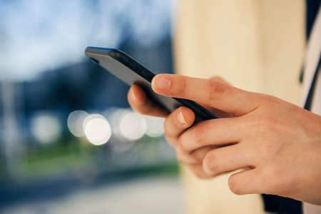 Girl with a smart phone in the city in a sunny day