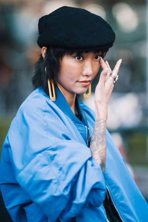 Milan, Italy - September 23, 2017: Asian girl with a stylish outfit posing on the street during Milan Fashion Week.のeditorial素材