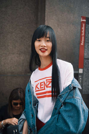 Milan, Italy - September 23, 2017: Asian girl with a stylish outfit posing on the street during Milan Fashion Week.のeditorial素材