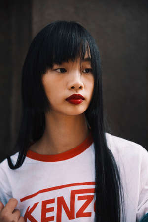 Milan, Italy - September 23, 2017: Asian girl with a stylish outfit posing on the street during Milan Fashion Week.のeditorial素材