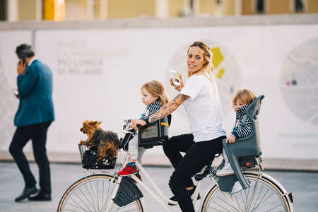 Milan, Italy - September 21, 2018: Beautiful mother with children on a bike in Milanのeditorial素材