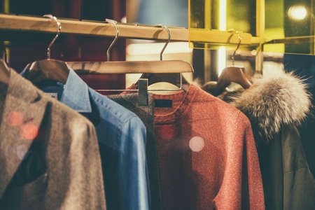 Men elegant clothing on hangers in a store in Milan.の写真素材