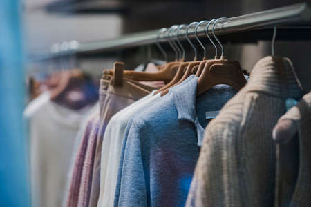 Men clothing on hangers in a fashion store in Milan.の写真素材