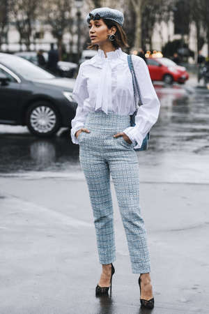 Paris, France - March 5, 2019: Street style - Woman wearing wearing a white shirt, light blue pants, black heels, light blue hat and printed Chanel bag, before a fashion show during Paris Fashion Week - PFWFW19のeditorial素材
