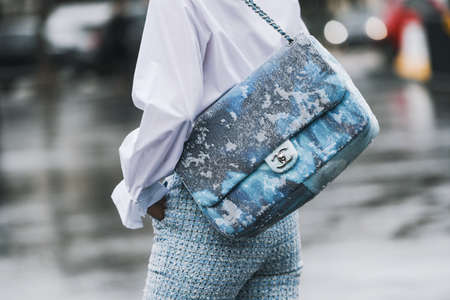Paris, France - March 5, 2019: Street style - Woman wearing wearing a white shirt, light blue pants, black heels, light blue hat and printed Chanel bag, before a fashion show during Paris Fashion Week - PFWFW19のeditorial素材
