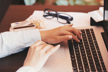 woman holding credit card and using laptop - online shopping conceptの写真素材