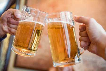 Close-up of two men toasting with beerの写真素材