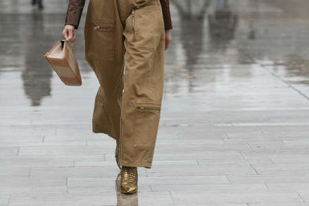 Paris, France â March 2, 2020: Woman wearing cargo trousers and a gold patterned handbag - streetstylefw20のeditorial素材