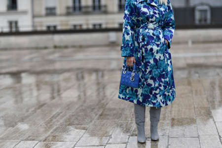 Paris, France â March 2, 2020: Woman wearing a blue floral patterned coat, high heel boots and a blue leather Dior handbag - streetstylefw20のeditorial素材