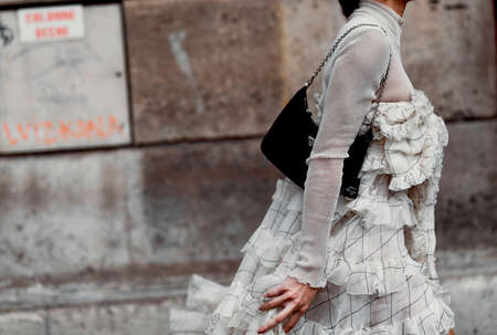 Paris, France â March 2, 2020: Woman wearing a ruffled dress and a black Prada chain bag - streetstylefw20のeditorial素材