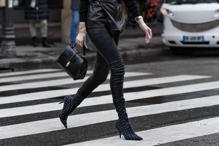 Paris, France â March 2, 2020: Woman wearing a black leather outfit matched with a black leather handbag and pointed high heel boots with diamond details - streetstylefw20のeditorial素材
