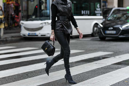 Paris, France â March 2, 2020: Woman wearing a black leather outfit matched with a black leather handbag and pointed high heel boots with diamond details - streetstylefw20のeditorial素材