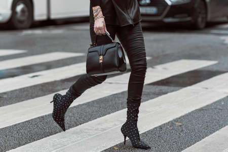 Paris, France â March 2, 2020: Woman wearing a black leather outfit matched with a black leather handbag and pointed high heel boots with diamond details - streetstylefw20のeditorial素材
