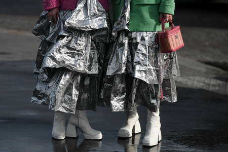 Paris, France â March 3, 2020: Women wearing silver ruffled maxi dresses and white leather high heel boots - streetstylefw20のeditorial素材